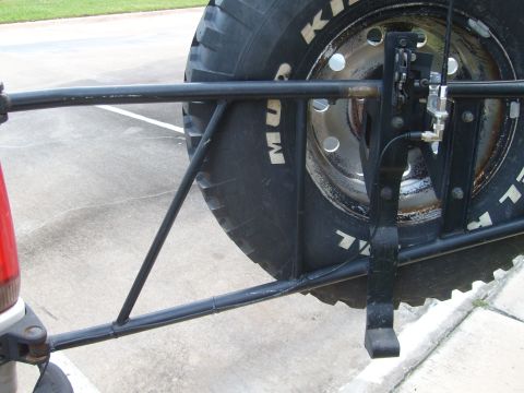 1992 Ford Bronco - Close-up of a spare tire carrier and CB antenna assembly on the back of a vehicle.