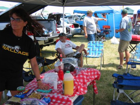 1985 Ford Crown Victoria LTD - Outdoor gathering with multiple vehicles present, people relaxing under tents.