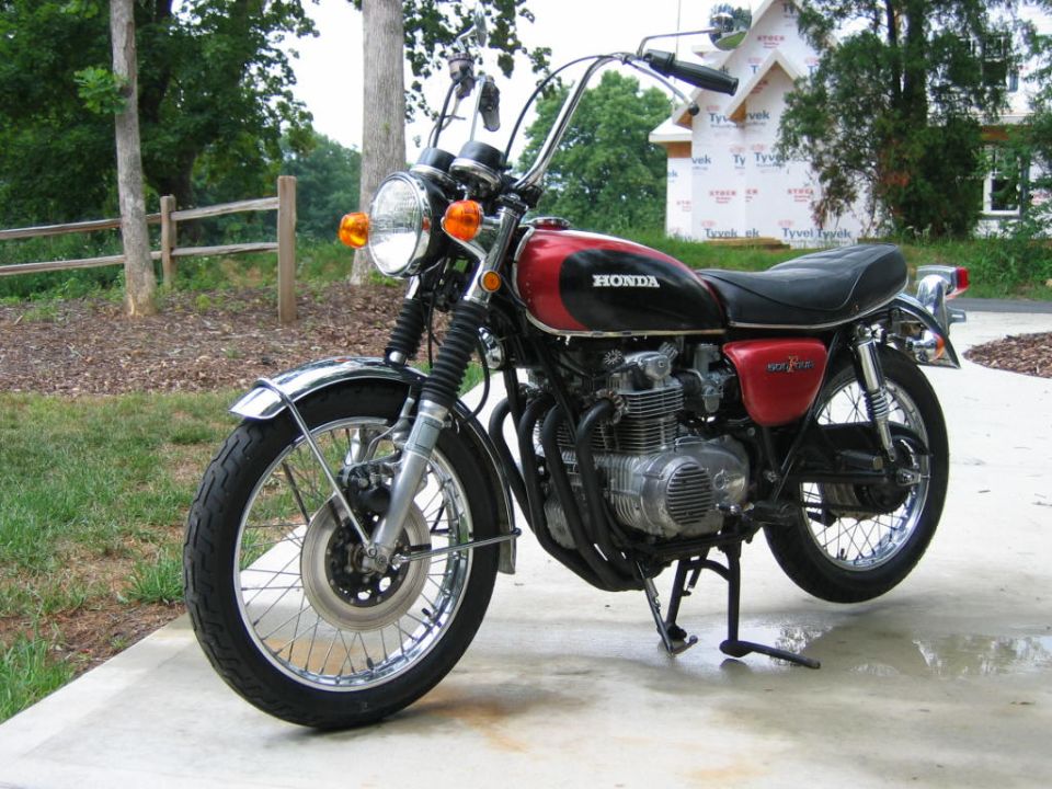 Honda CB500 motorcycle, red and black tank, chrome fenders, parked on concrete