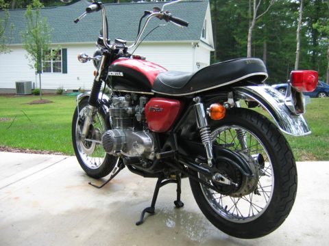 1985 Ford Crown Victoria LTD - A vintage Honda motorcycle with chrome accents sits parked outside a house.
