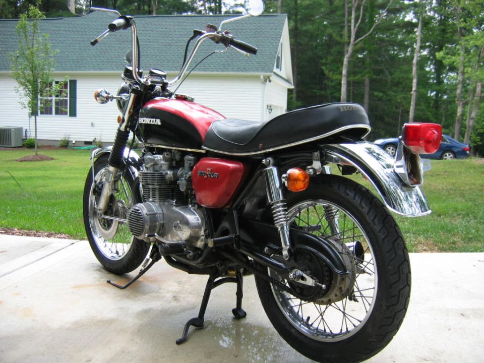 Black and red Honda motorcycle, side view, with chrome accents and a black seat
