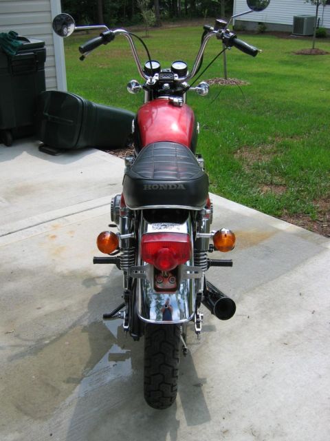 1985 Ford Crown Victoria LTD - Rear view of a red Honda motorcycle parked on a concrete driveway.
