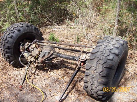 1978 Ford Bronco - A vehicle's front axle assembly with large off-road tires is shown outdoors.