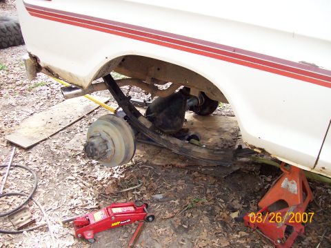 1978 Ford Bronco - The rear axle and leaf springs of a 1978 Ford Bronco are visible while it is supported by jack stands.