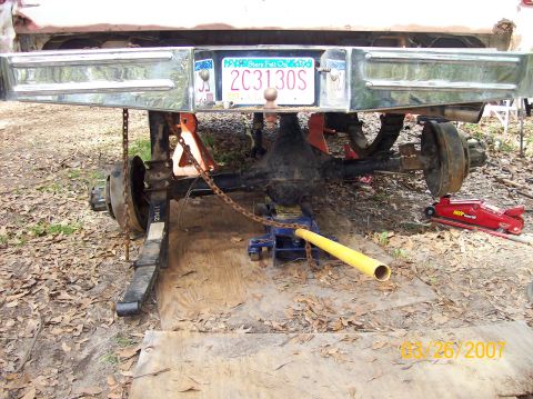 1978 Ford Bronco - Vehicle's rear axle assembly is being worked on, supported by jack stands.