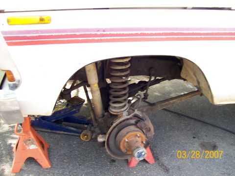 1978 Ford Bronco - Front suspension of a 1978 Ford Bronco undergoing maintenance, with wheel removed.