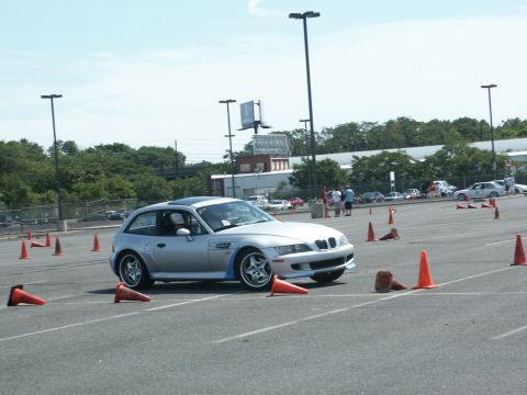 2001 Mercury Grand Marquis - A silver BMW Z3 Coupe navigates an autocross course marked by orange cones on a sunny day.