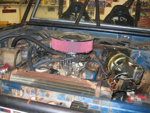 1992 Ford Mustang - Engine bay of a 1974 Ford Bronco, modified with a roll cage and aftermarket air intake.