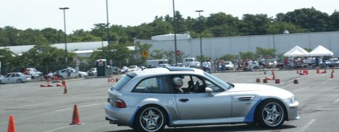 2001 Mercury Grand Marquis - A silver BMW M coupe navigates an autocross course with a driver wearing a helmet.