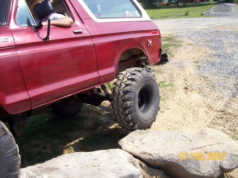 1978 Ford Bronco - This red SUV is navigating a rocky obstacle course, its off-road capabilities.