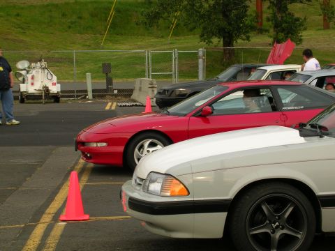 1996 Ford Probe - Two cars, a red 1996 Ford Probe and a white car, are parked at an event.