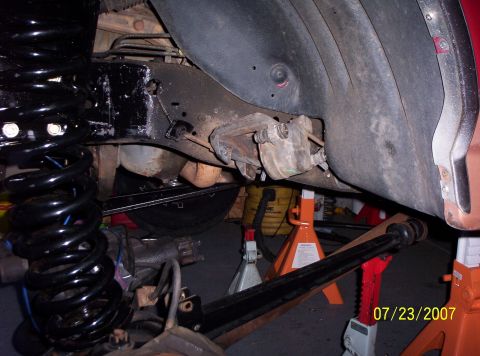 1995 Ford Bronco - Vehicle suspension components, including a coil spring and brake caliper, are visible on jack stands.