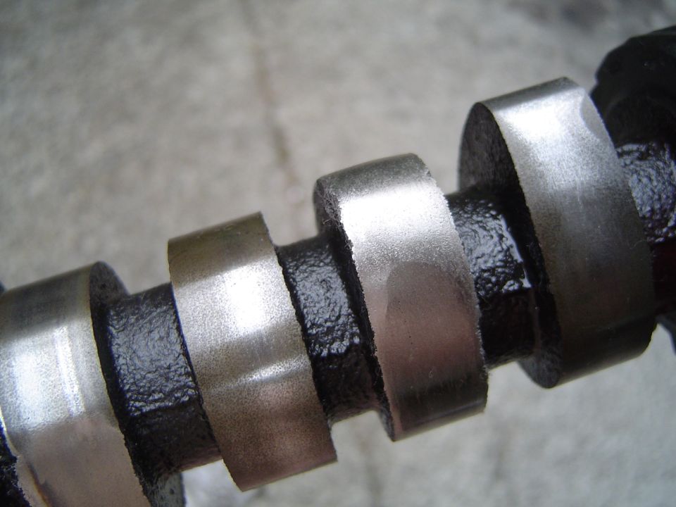 Engine camshaft lobes and journals close-up on concrete