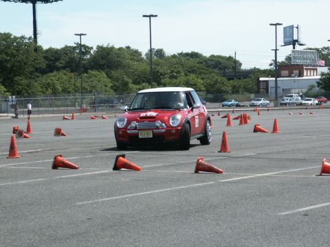 2001 Mercury Grand Marquis - A red Mini Cooper navigates an autocross course on a sunny day.