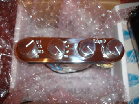 1977 Ford F-150 - A chrome air conditioning control panel with four knobs is shown, wrapped in bubble wrap.