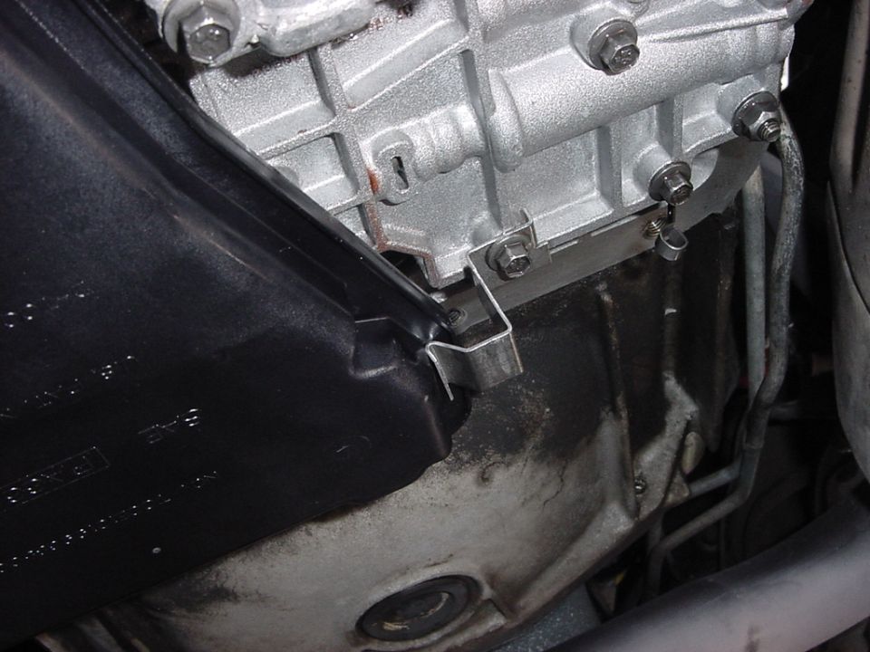 Aluminum transmission case with small steel bracket viewed from under the vehicle