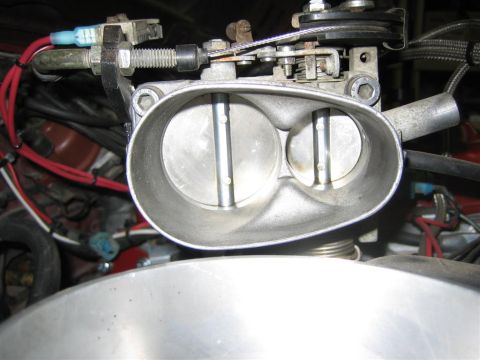 1987 Suzuki Samurai - Close-up of a throttle body assembly, showing the internal butterflies and linkage mechanism.