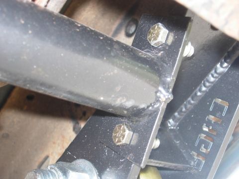 1995 Ford Bronco - A close-up view shows a metal bracket and bolts, likely part of a vehicle's suspension or frame modification.