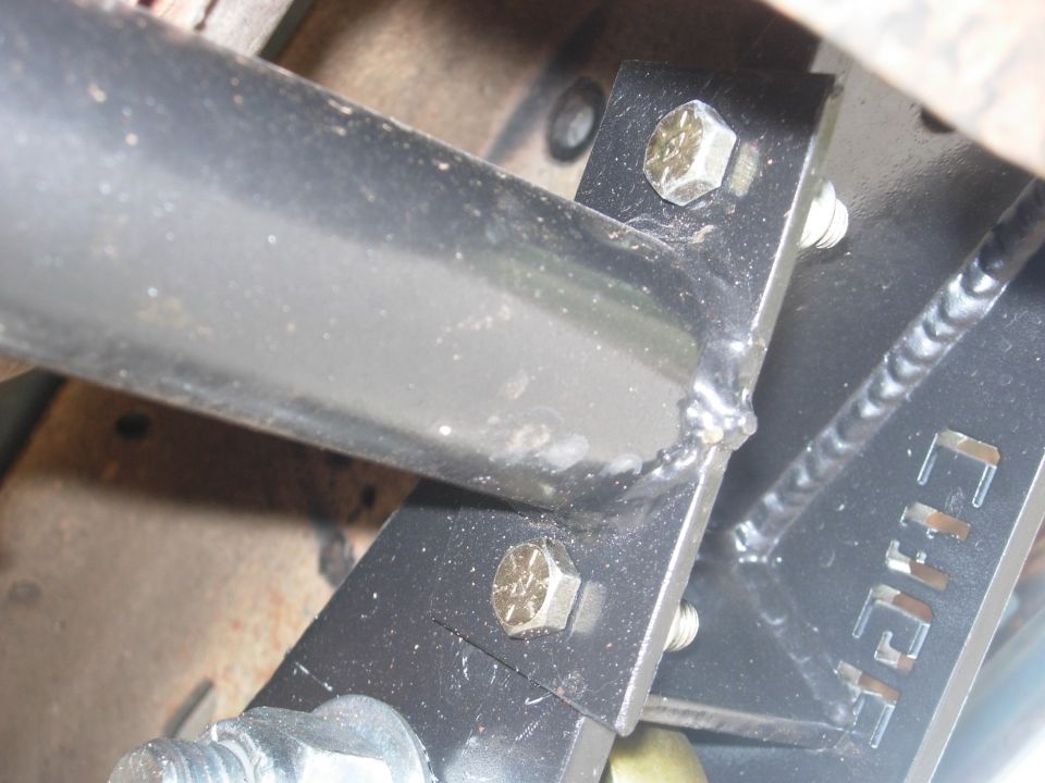 Close-up of welded and bolted black steel Cage suspension bracket under a truck