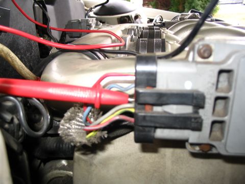 1993 Ford Taurus - Close-up of a vehicle's engine bay showing electrical diagnostics with a multimeter.