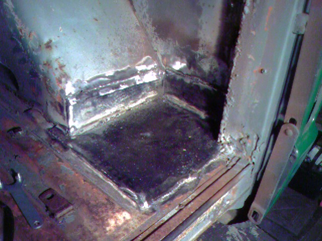 Interior corner with rust and new welds, showing metal repair work