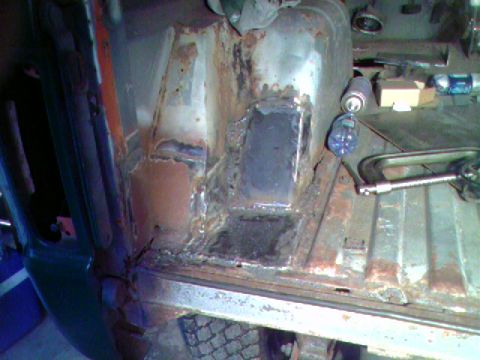 1974 Ford Bronco - Floor pan repair in progress, showing rust and a newly welded patch panel.