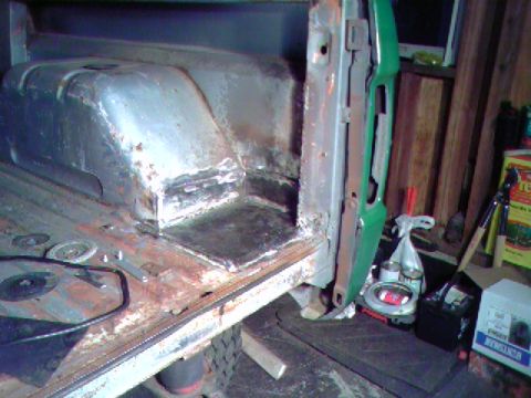 1974 Ford Bronco - The interior rear cargo area of a vehicle shows signs of rust repair and welding work.