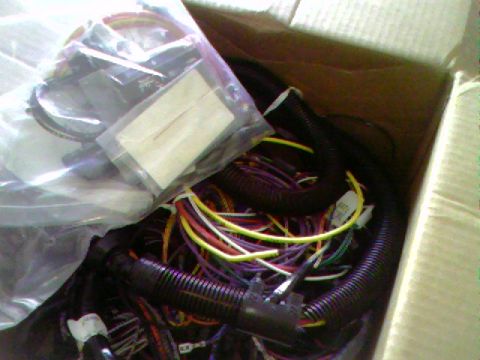 1974 Ford Bronco - A box filled with various automotive wiring harnesses, showing a tangle of colorful wires and protective tubing.