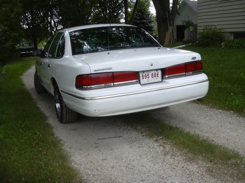 1997 Ford Crown Victoria - Rear view of a white 1997 Ford Crown Victoria parked on a gravel driveway.