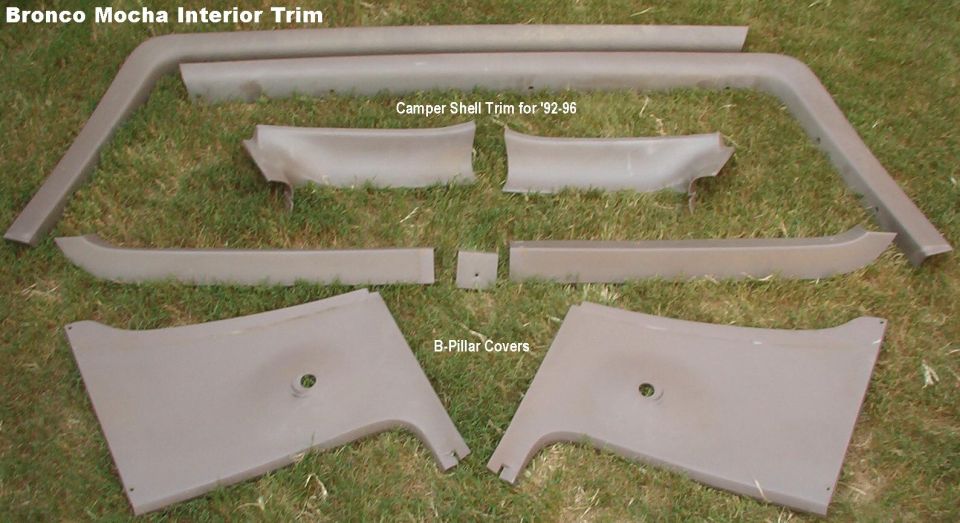 Mocha-colored Bronco interior trim panels laid on grass, labeled