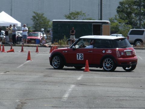 2001 Mercury Grand Marquis - A red Mini Cooper with a white roof and the number 73 on its door participates in an autocross event.