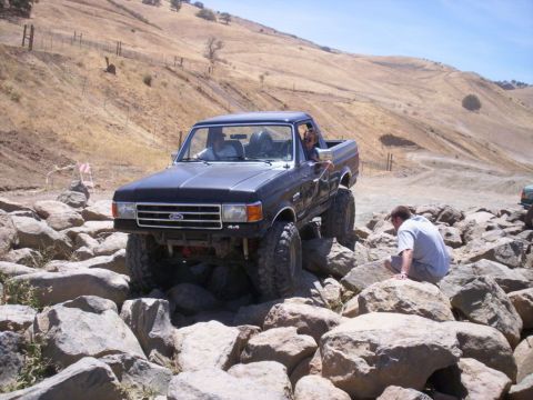 1989 Ford Bronco - This lifted Ford F-Series truck is navigating a challenging rocky obstacle course.
