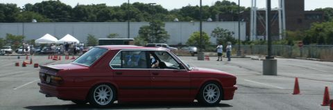 2001 Mercury Grand Marquis - A red sedan navigates a course marked by orange cones in a parking lot.