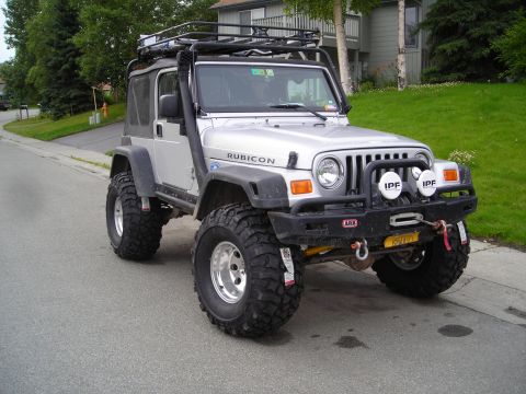 2003 Jeep TJ - This modified Jeep Wrangler Rubicon is equipped for off-road adventures with its snorkel, roof rack, and heavy-duty bumper.