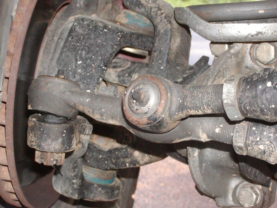 Steering linkage tie rod ends and ball joint close-up under a vehicle