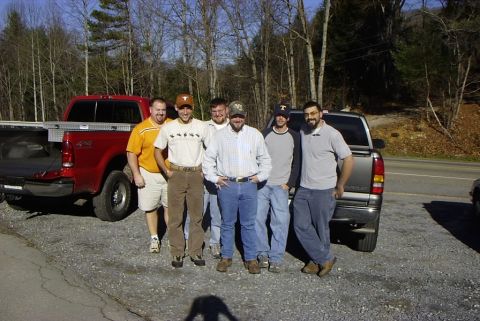1995 Ford Bronco - A group of men pose for a photo with two pickup trucks in a wooded area.