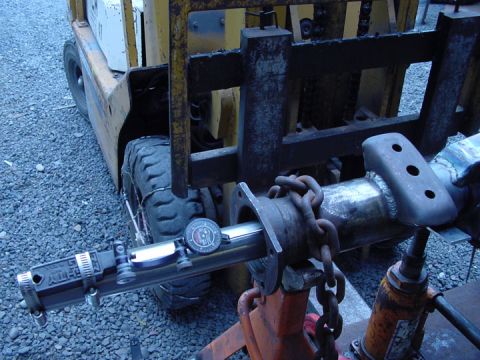 1979 Ford Bronco - Forklift and axle part being measured with a dial indicator, supported by jack stands.