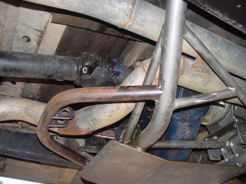 1979 Ford Bronco - Close-up of the undercarriage showing the driveshaft, exhaust, and a custom roll cage structure.