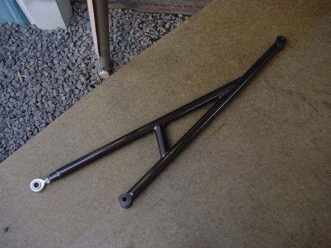 1979 Ford Bronco - A black metal traction bar, likely for a vehicle's suspension, is shown on a concrete surface.
