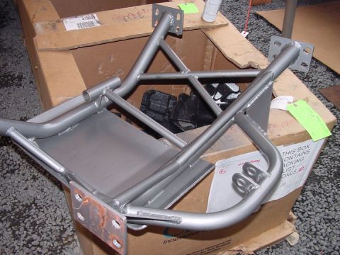 1979 Ford Bronco - A metal traction bar assembly is shown inside a cardboard box, with some of its mounting brackets showing rust.