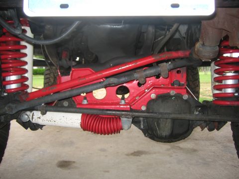 2001 Jeep Wrangler - The underside of a Jeep shows red suspension components and steering linkage.