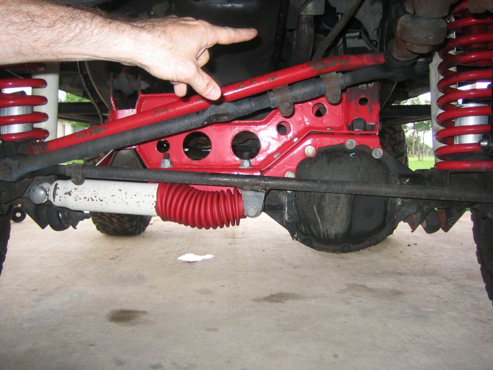 Red steering stabilizer and suspension components on a Jeep Wrangler