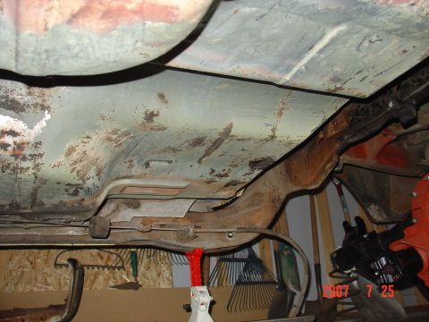 1973 Ford Ranchero - The undercarriage of a 1973 Ford Ranchero displays significant rust on the floorboards and frame.