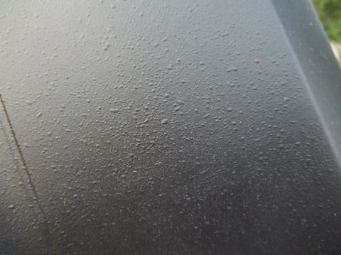 1987 Ford Bronco - Water beads form on the surface of a vehicle's hood after rain.