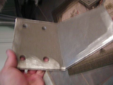 1991 Ford Bronco - A metal bracket with four mounting holes is shown.