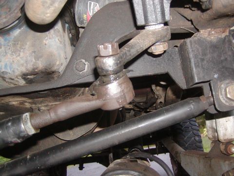 1991 Ford Bronco - Close-up view of the steering linkage components, including tie rod ends and drag link, on an unidentified vehicle.