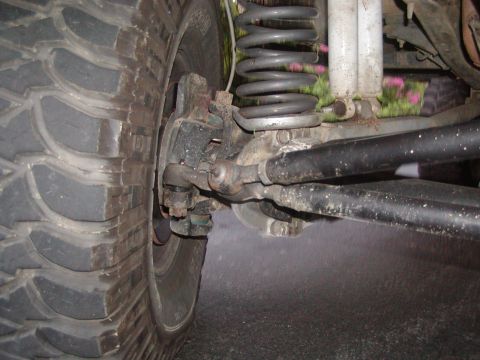 1991 Ford Bronco - This image shows the intricate steering and suspension system of a vehicle, focusing on the front wheel assembly.