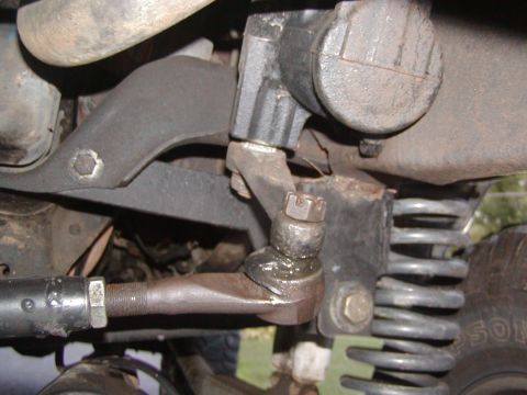 1991 Ford Bronco - Undercarriage view of a vehicle's steering and suspension system, with visible grease and metal parts.
