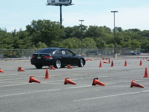 2001 Mercury Grand Marquis - A black sedan navigates an autocross course marked by orange cones, with another vehicle visible in the background.
