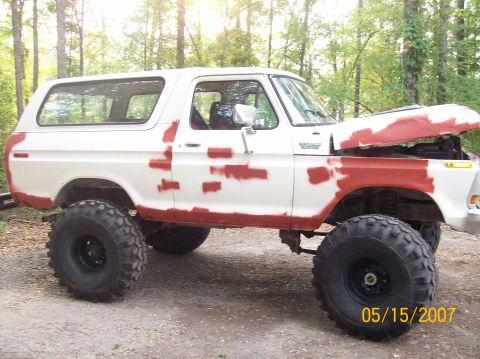 1978 Ford Bronco - A 1978 Ford Bronco is shown with primer patches on its body and its hood raised, parked outdoors.